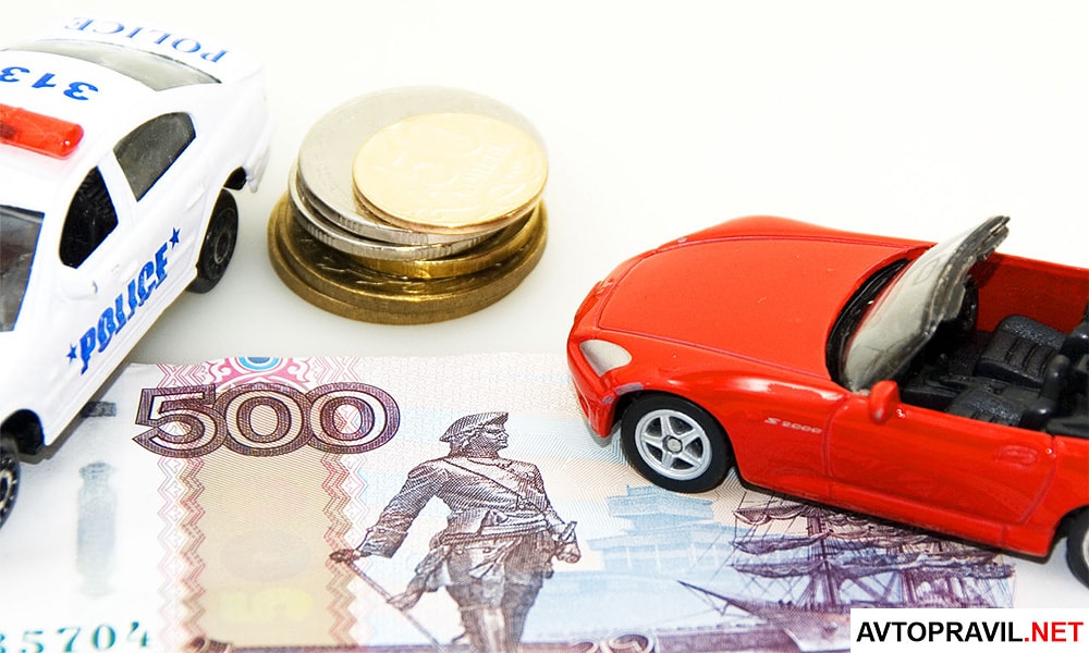Два игрушечных автомобиля и рубли, лежащие на столе