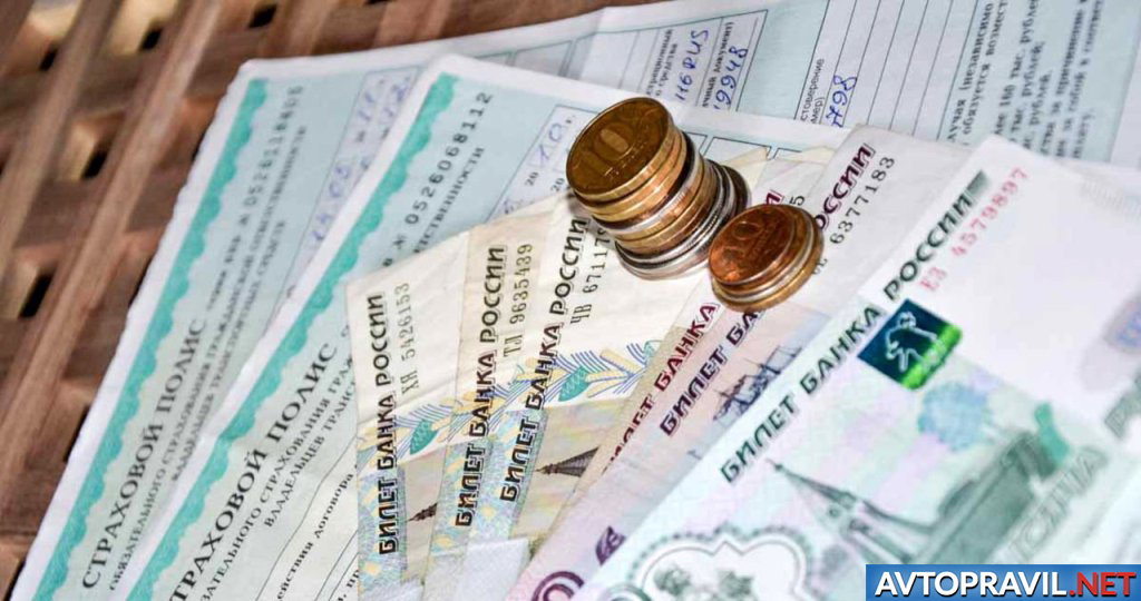 Купюры и монеты, лежащие на страховых полисах